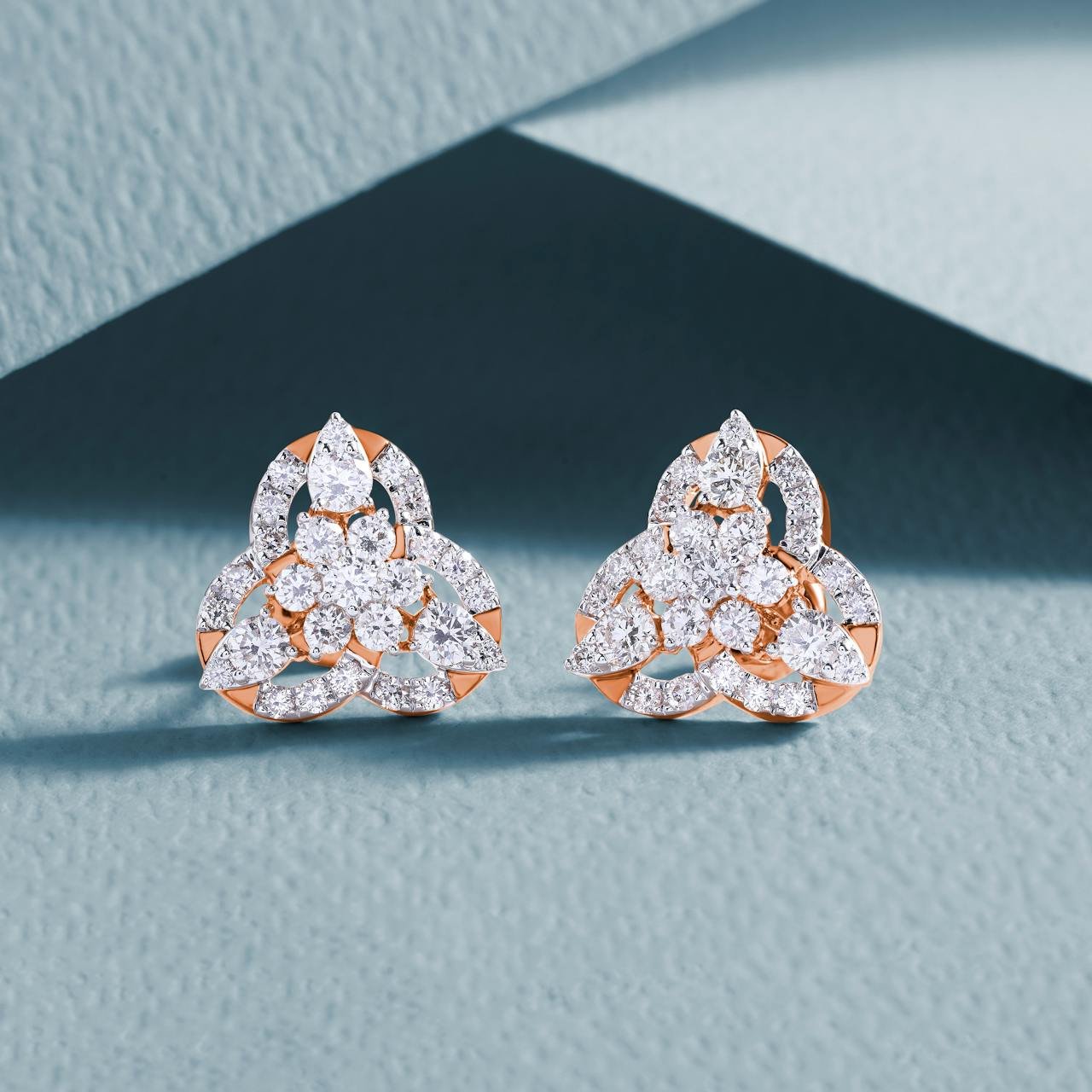 services-01 Luxurious diamond earrings with an intricate design on a textured background.